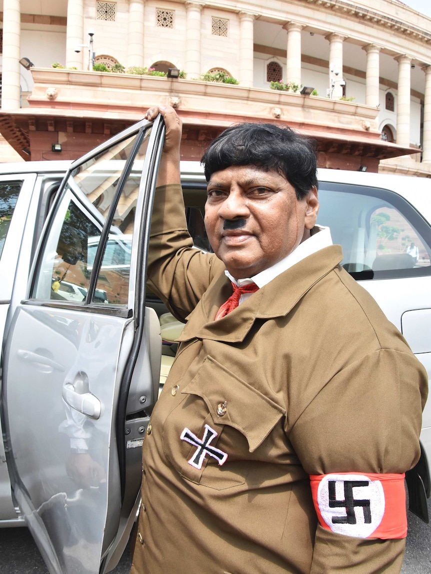 An Indian MP dressed as Hitler gets out of a car outside Indian parliament