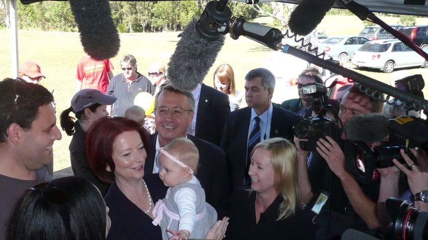 The first full day of campaigning has seen Julia Gillard hug babies in Brisbane.