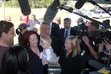 Julia Gillard holds a baby in Brisbane on day one of the 2010 election campaign