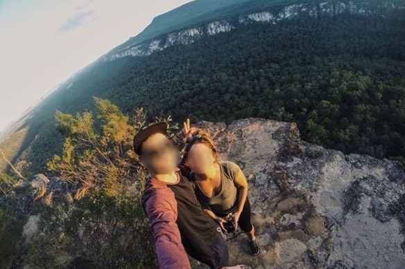 A couple taking a selfie on a cliff edge.