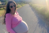Natalie pictured heavily pregnant standing in front of a road in San Francisco.