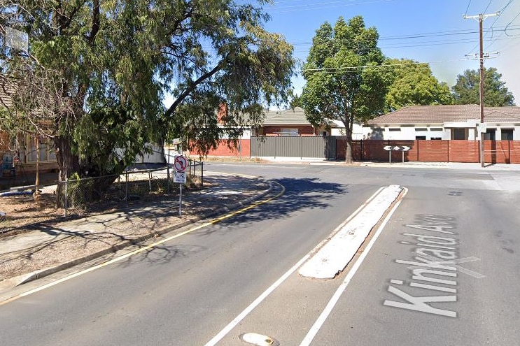 A suburban street with a no left turn sign.