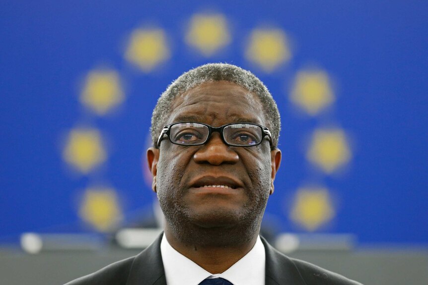 Congolese gynaecologist Denis Mukwege stands in front of the European Union flag.