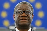 Congolese gynaecologist Denis Mukwege stands in front of the European Union flag.