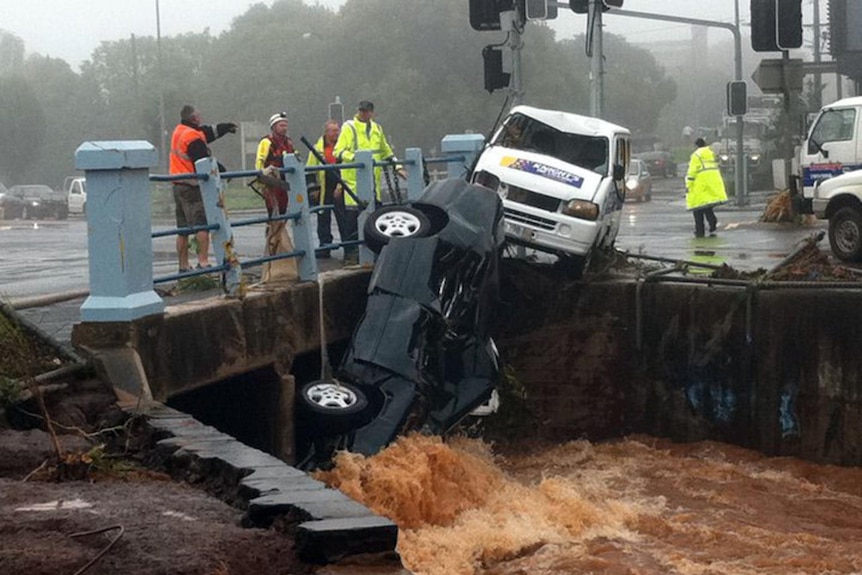 Floodwaters wash a car against a bridge over the Chalk St River in Toowoomba on January 10, 2011.