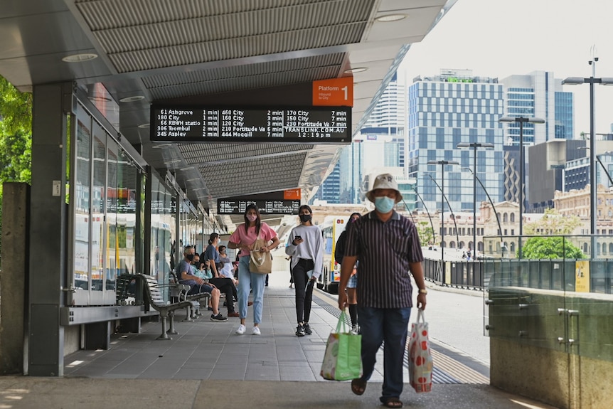 People in COVID face masks at the Brisbane Cultural Center