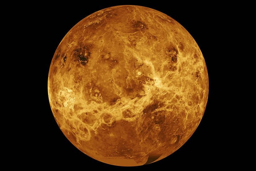 Venus appears as a yellowed marble, cracks run across its face