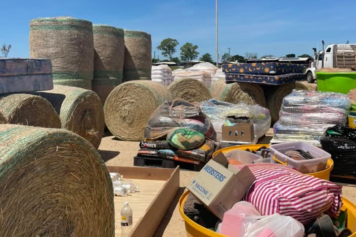 A large area full of hay bales and other items for flood-ravaged communities