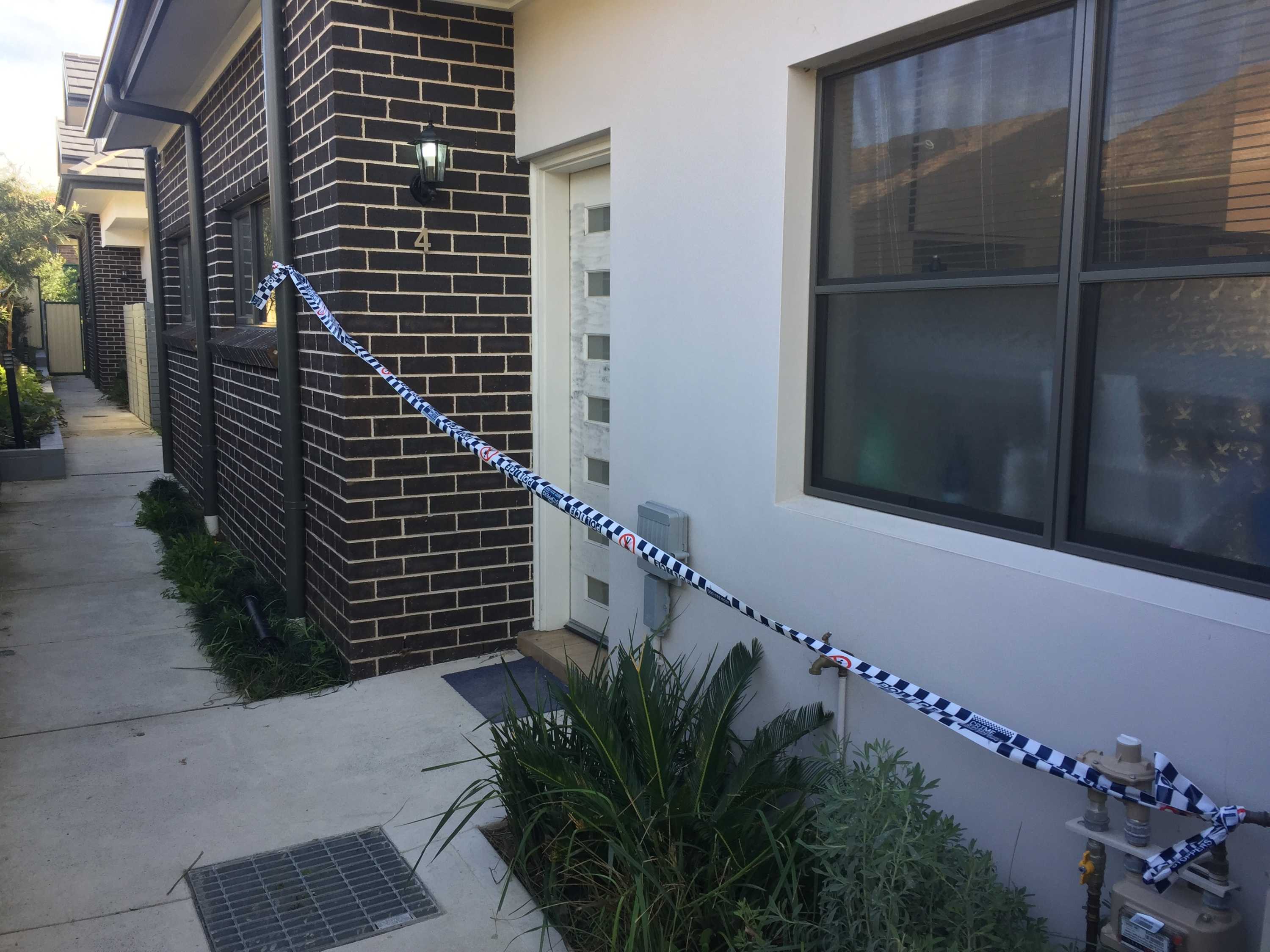 Police tape across the entrance to a town house at Campsie.