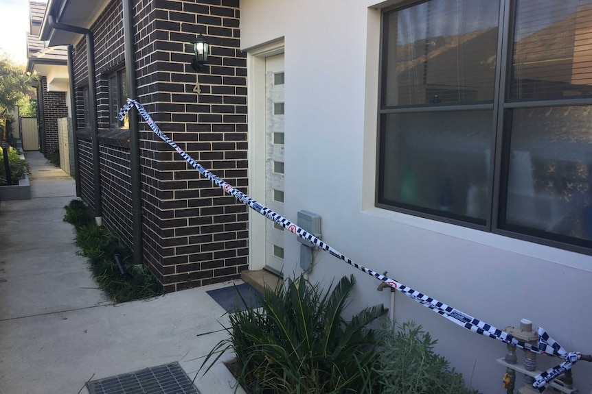 Police tape across the entrance to a town house at Campsie.