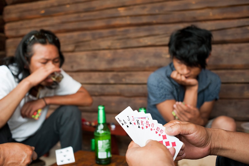 Young Mosuo men enjoy beer and a card game