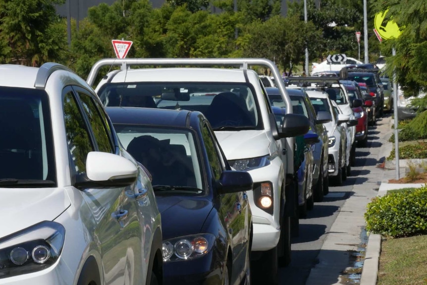 Cars wait in a line on a street.