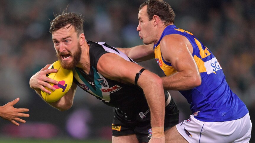 Charlie Dixon looks to break a Shannon Hurn tackle.