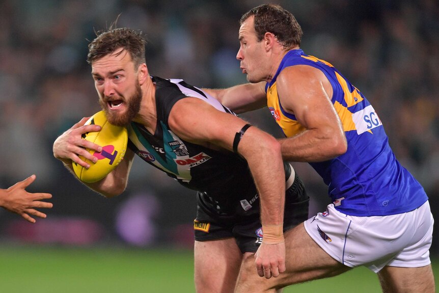 Charlie Dixon looks to break a Shannon Hurn tackle.