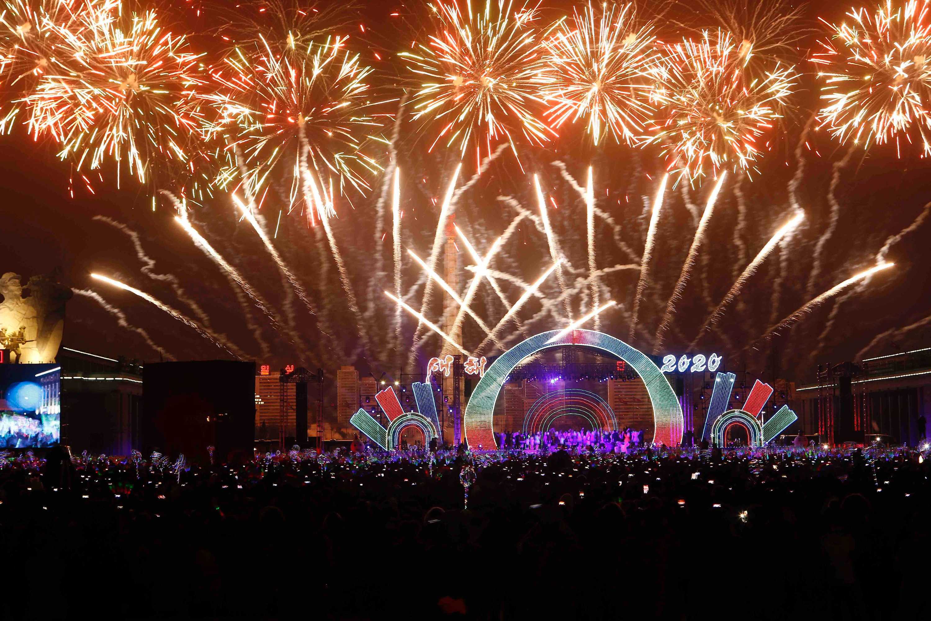 A crowd is seen in front as colourful fireworks explode in the sky.