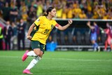 Sam Kerr running with hand in a fist.