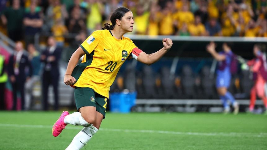 Sam Kerr running with hand in a fist.