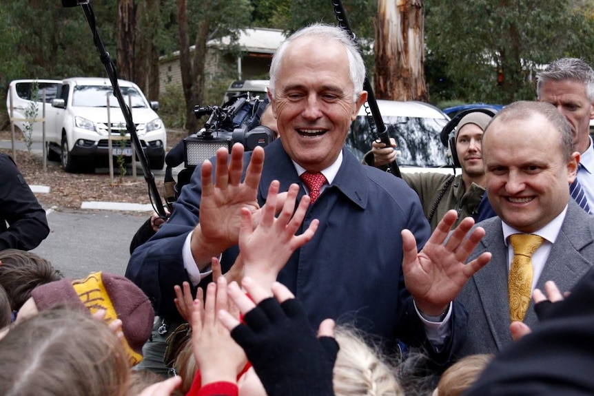 Malcolm Turnbull high fives school children in Victoria.