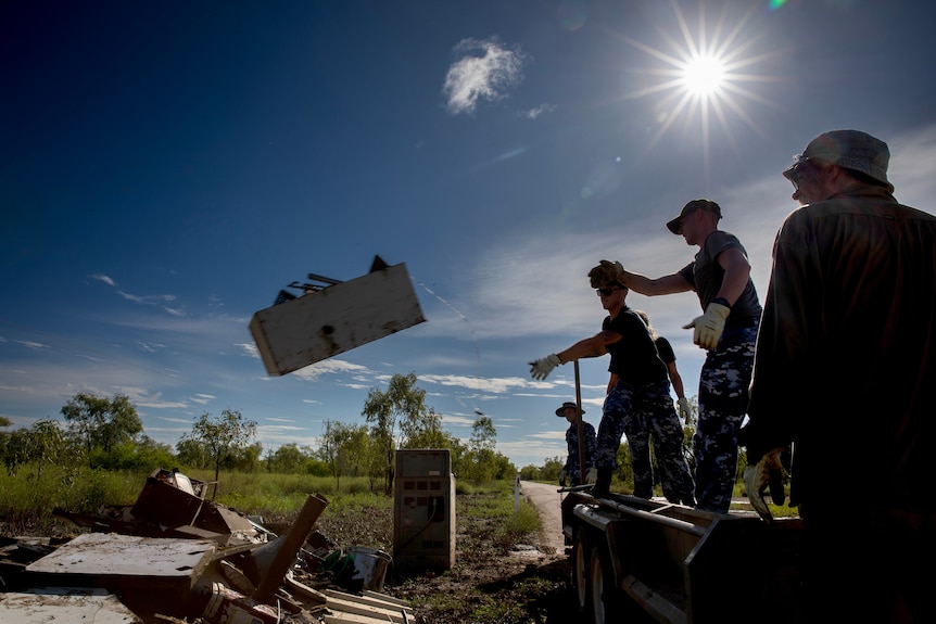 Army throw rubbish from homes into a big pile