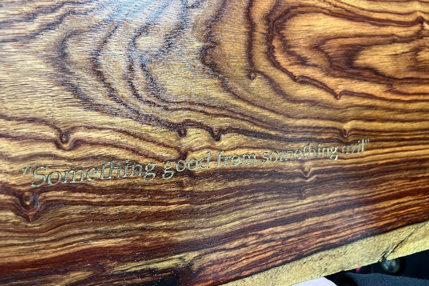 An engraving into wood that says "Something good from something evil"