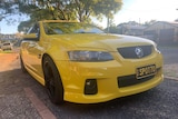 Yellow Holden Commodore with the number plates Spotto