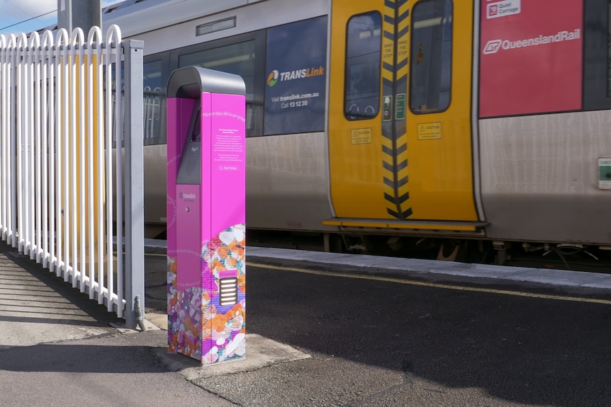 Image of pink rectangle ticket reader for go card, in front of train