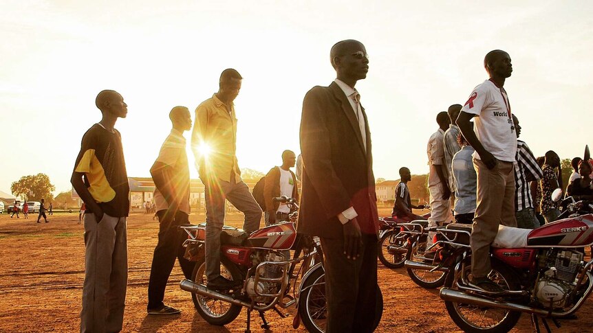 Young South Sudanese men wait for a community celebration in Torit.