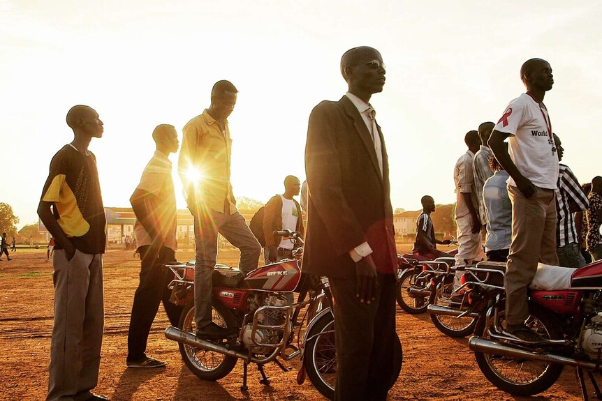 Young South Sudanese men wait for a community celebration in Torit.
