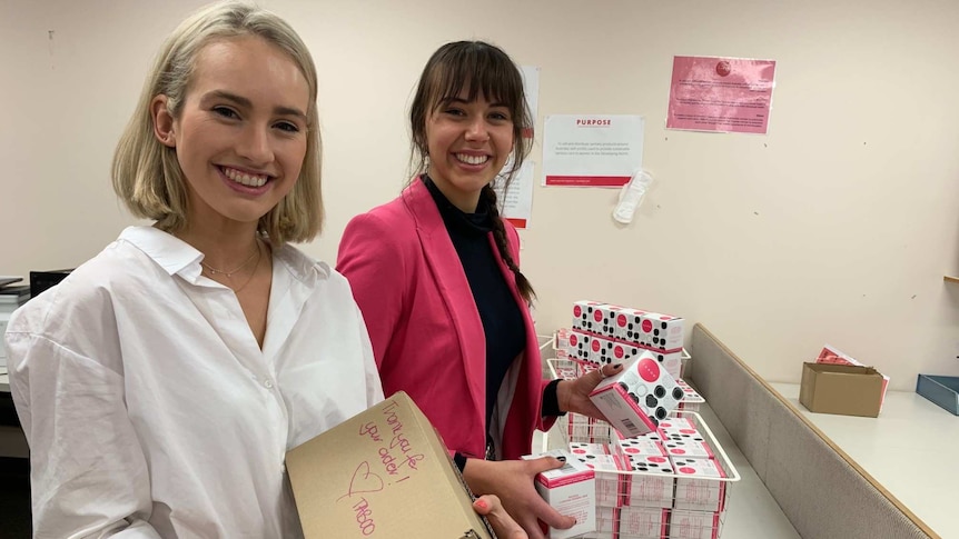 Two women holding cardboard boxes