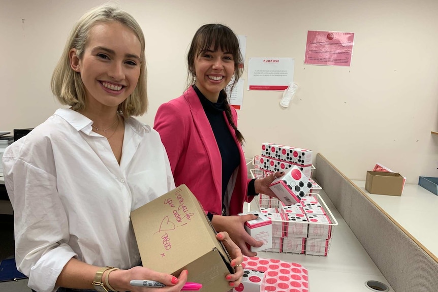 Two women holding cardboard boxes