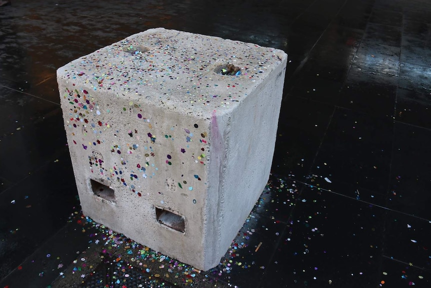A bollard covered in colourful glitter outside Southern Cross Station