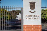 A sign with the words Redfield College next to a metal gate 