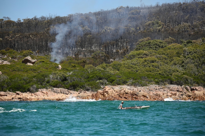 Kayaker watches fire in bushland at Eagle Bay