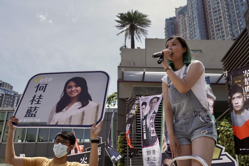 A woman using mic to speak in a public gathering in Hong Kong