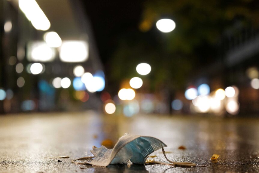 A used protective mask is left in an pedestrian area.