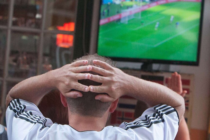 A football fan reacts while watching the FIFA World Cup final between Germany and Argentina.