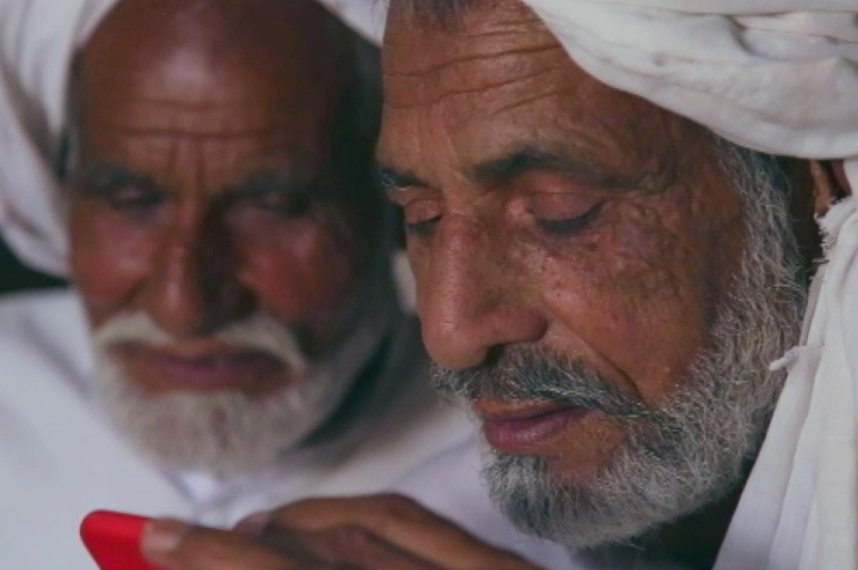 Mohammad Rafiq and Mohammed Iqbal speak to their sister during a video call.