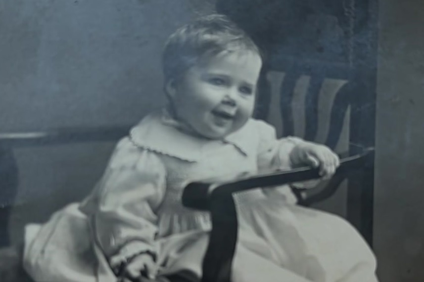 An old black and white photo of a baby about one year old