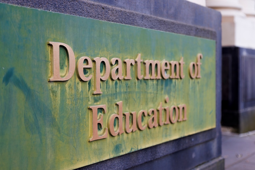 An embossed metal sign on a building that reads "Department of Education".