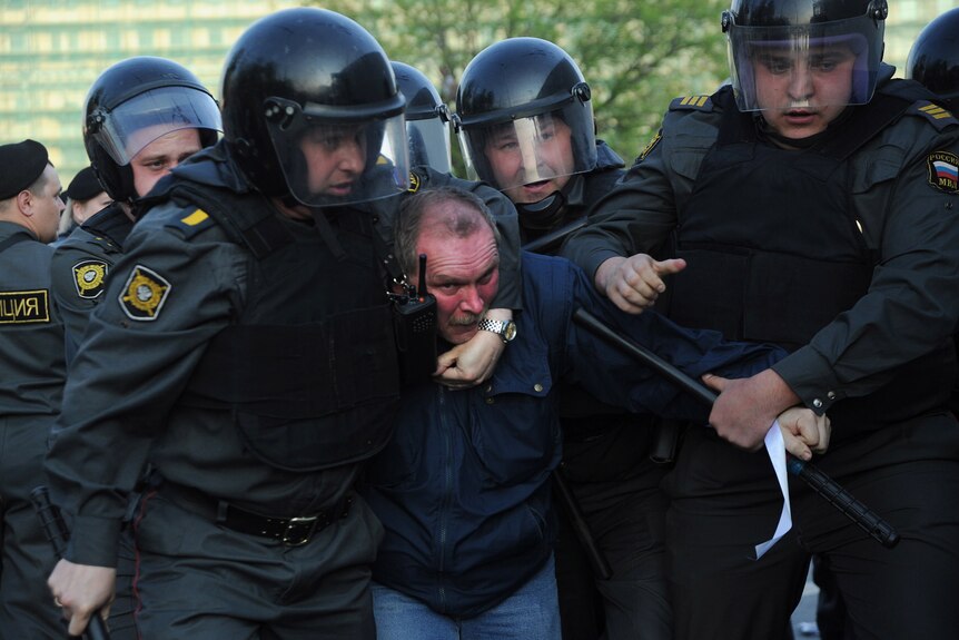 Russian police officers detain opposition supporters during an anti-Putin rally