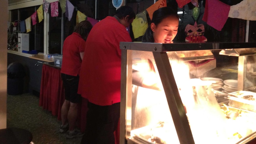 Ashley Leong serves food at the Red Cross Night Cafe in Brisbane