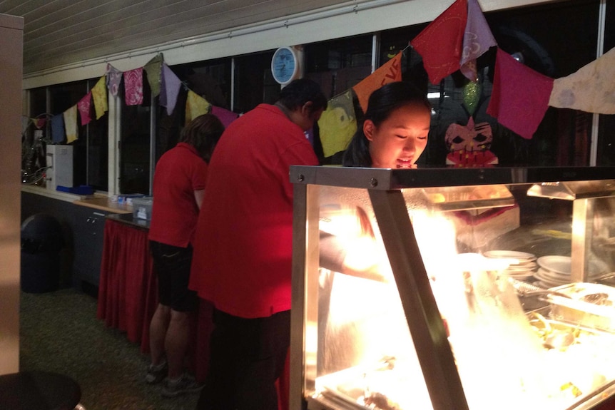 Ashley Leong serves food at the Red Cross Night Cafe in Brisbane