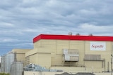 A factory with a red roof and Saputo written on the side.