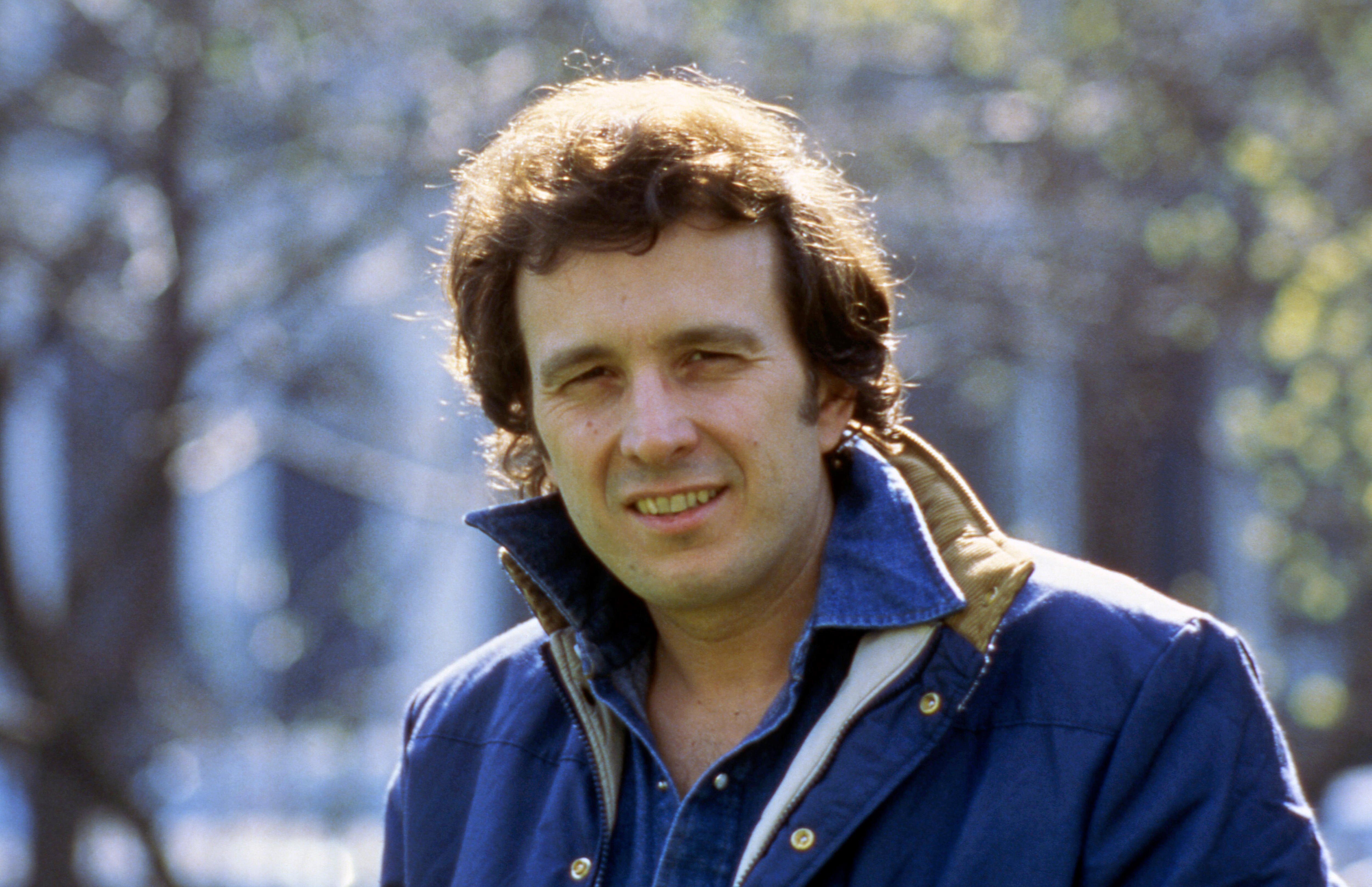 A younger Don McLean with a full head of hair poses for a portrait wearing a blue jacket on a cold sunny day.