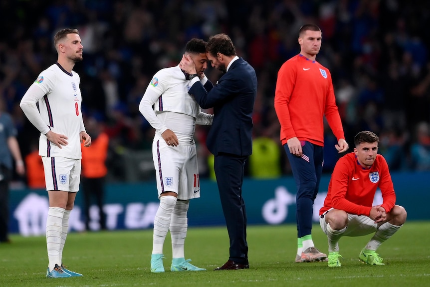 Gareth Southgate tient la tête de Jadon Sancho dans ses mains alors qu'ils se tiennent front contre front