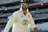 Nathan Lyon smiles as he walks off the field