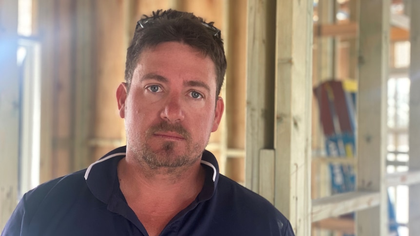 Rockhampton builder Sonny-Jim Fulton stands with a stern look on his face.