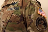 A close up of a American camouflage military uniform with the United States Space Command logo on the arm.