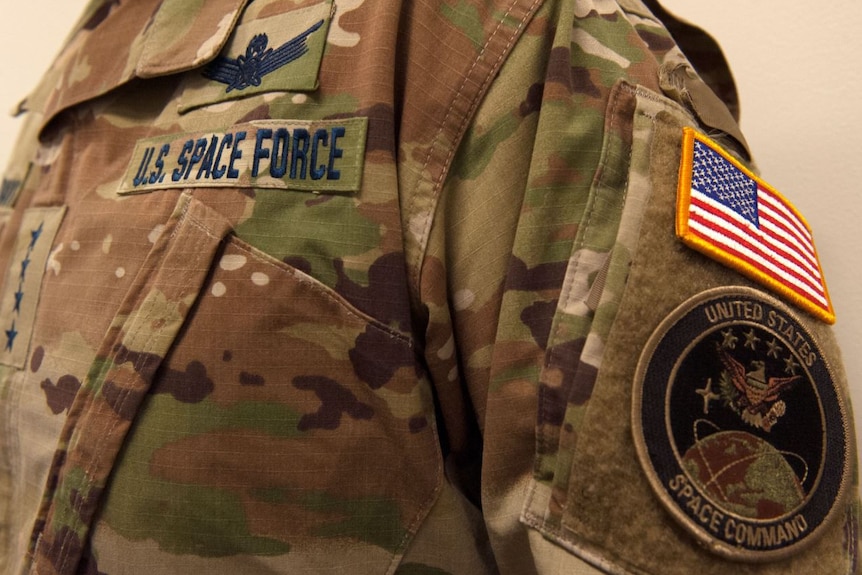 A close up of a American camouflage military uniform with the United States Space Command logo on the arm.