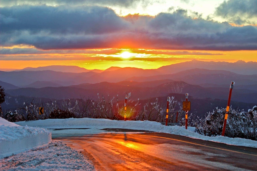 snow on mountain overlooking sunset